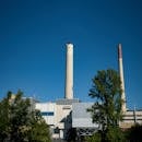 A view of an industrial plant with smokestacks under a clear blue sky in Pforzheim, Germany.