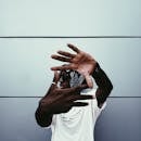 Fashionable person using hands to create a frame, stylish background.